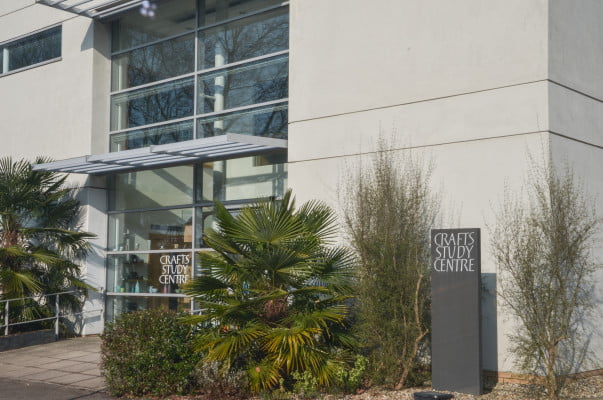 Outside of a white modern building with small trees in front