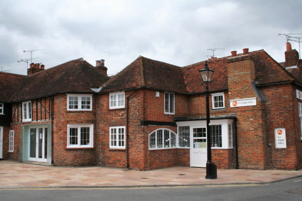 Exterior of large red brick building, with white windows.