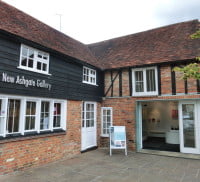 red brick building white doors & windows. dark wooden panels and tiled roof.