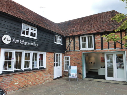 red brick building white doors & windows. dark wooden panels and tiled roof.