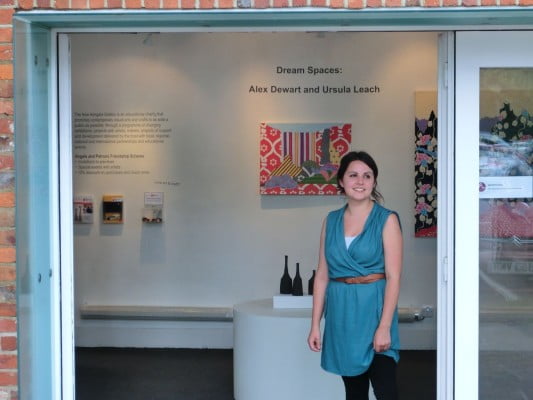 female in a doorway, art in the background