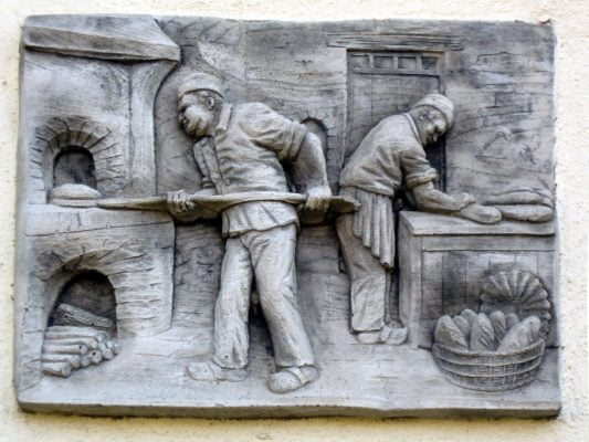 Plaque showing bakers putting bread in oven