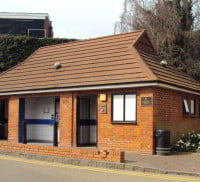 Outside toilet building. Flowers to right hand side.