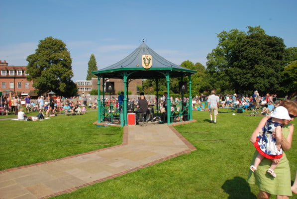 Bandstand, with crowd behind. Band playing inside.