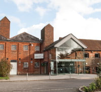 Outside of Farnham Maltings. Red brick building. Glass fronted entrance.