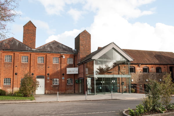 Outside of Farnham Maltings. Red brick building. Glass fronted entrance.