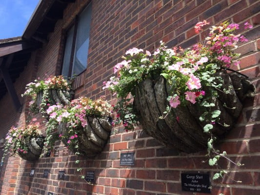 Wall displaying plaques and hanging baskets.