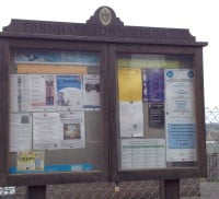 Wooden noticeboard. Posters