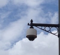 CCTV camera on decorative bracket. Blue sky and white clouds. © Farnham Town Council