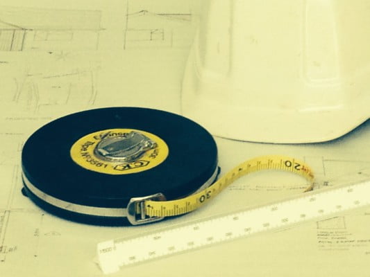 Tape measure, hard hat, scale rule and plans