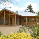 Wooden building with bushes surrounding it.