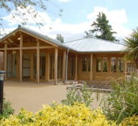 Wooden building with bushes surrounding it.