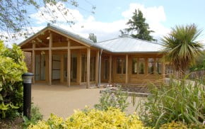 Wooden building with bushes surrounding it.