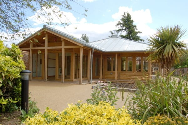 Wooden building with bushes surrounding it.