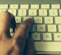 Hand typing on keyboard.