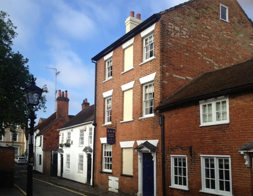 Tall brick building with blue sign and door.