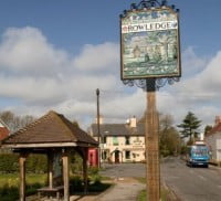 Bus shelter left, Rowledge village sign, pub in background