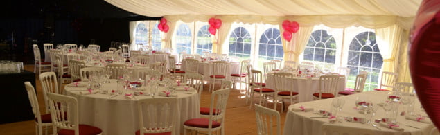 white tables and chairs, pink balloons in background.