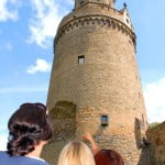 Tall stone round tower, three people, Andernach