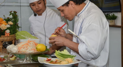 two males in chef whites cooking