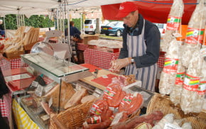 Stall with various meats and male stallholder