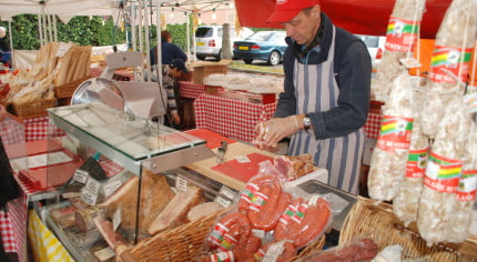 Stall with various meats and male stallholder