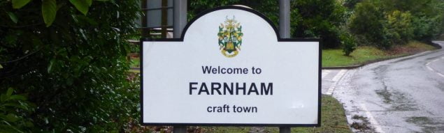 Road sign, with black writing and town council crest.