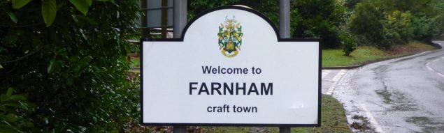 Road sign, with black writing and town council crest.
