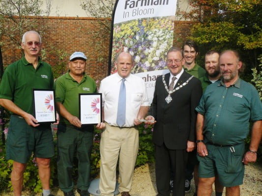 Seven men including Mayor, holding certificates and trophy for Farnham in Bloom.