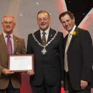 Three males holding certificate.