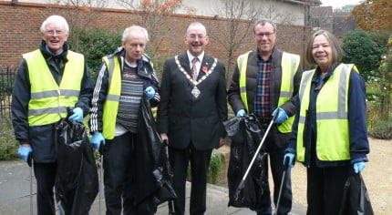 4 males and 1 female with black rubbish sacks and litter pickers.