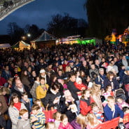 Crowd of people, bouncy castles and stalls in the background.