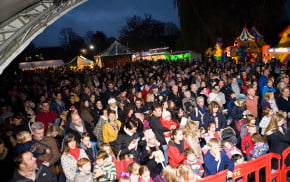 Crowd of people, bouncy castles and stalls in the background.