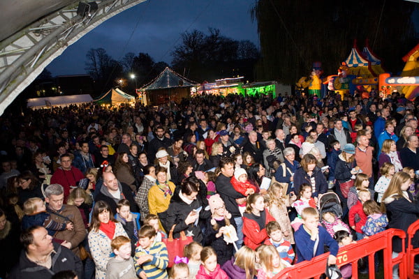 Crowd of people, bouncy castles and stalls in the background.