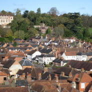 Town scene showing roof tops, trees and Castle in the background.