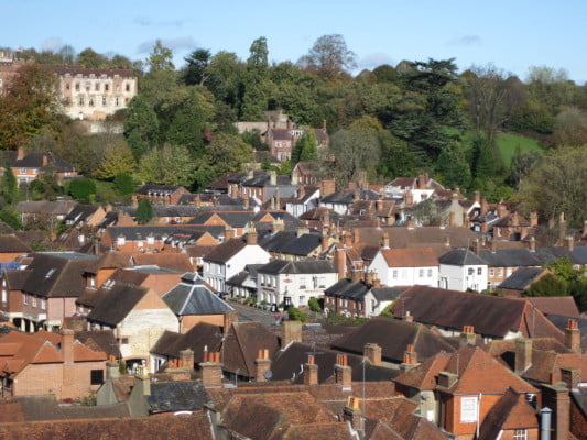 Town scene showing roof tops, trees and Castle in the background.