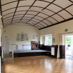 interior of village hall, domed roof, small stage with a table.