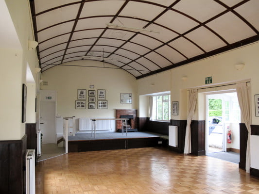 interior of village hall, domed roof, small stage with a table.