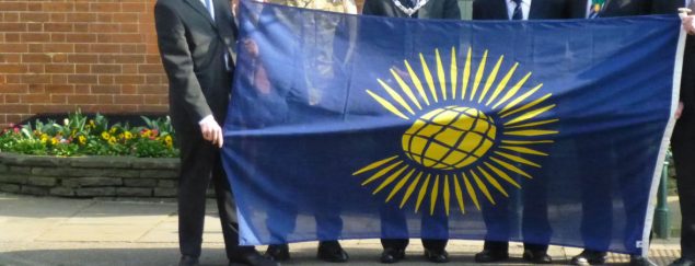 people holding Commonwealth flag