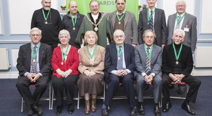 10 males and 2 females sitting after receiving awards.