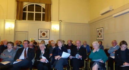 People sitting in room at a meeting.