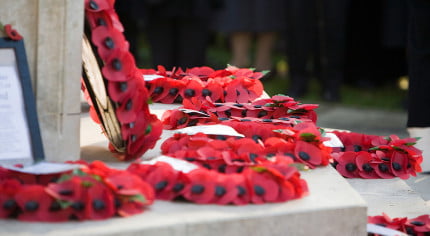 Poppy wreaths on base of war memorial.