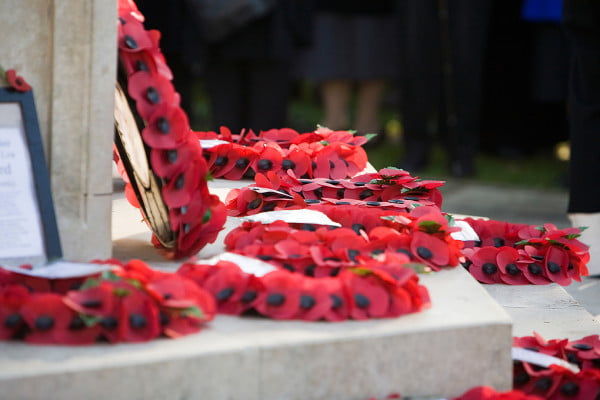 Poppy wreaths on base of war memorial.
