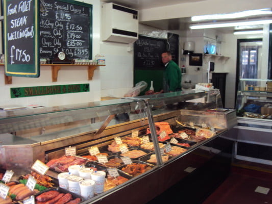 meat in a glass case, male in background.