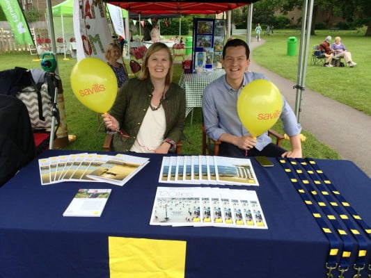 A female and a male sitting at a table holding balloons.