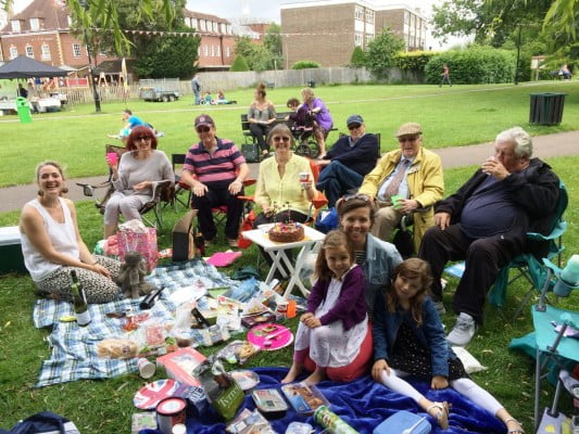 A group of adults and children having a picnic.