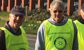 Seven men in high viz vest collecting litter.