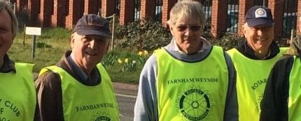 Seven men in high viz vest collecting litter.