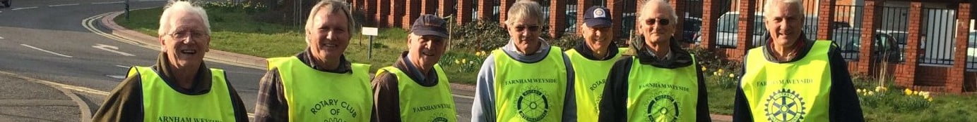 Seven men in high viz vest collecting litter.