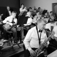 Black and white photo of band members playing musical instruments